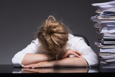 Image of overworked woman sleeping on desk at her workplace